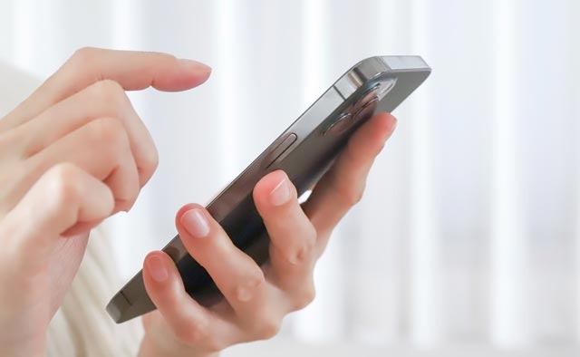 家族葬の渋谷区葬儀社に電話でお問合せしようとしている人の手元。